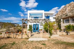 una casa bianca con una porta blu di Venetia's Garden a Lefkos Karpathou