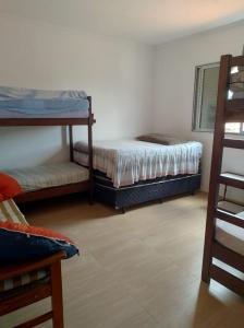 a bedroom with two bunk beds and a mirror at CASA TO Patrao LUXO in Itapecerica da Serra