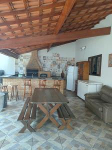 a living room with a table and a kitchen at CASA TO Patrao LUXO in Itapecerica da Serra