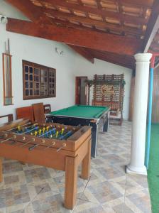 a room with a pool table and chairs at CASA TO Patrao LUXO in Itapecerica da Serra