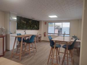 una sala de espera con mesas y sillas azules en Hostal Garamar, en Benicàssim