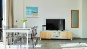 a living room with a tv and a table with chairs at Living4malaga Victoria Center Apartment in Málaga