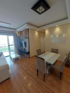 a living room with a table and chairs and a couch at Residencial Vitrine Esplanada in Votorantim +20 photos
