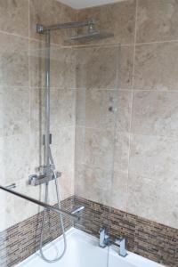 a shower with a glass door in a bathroom at Exquisite 3 Bedroom Home Central Birmingham in Birmingham