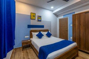 a bedroom with blue walls and a bed with blue pillows at Smart Stay by Luxe Gachibowli in Hyderabad