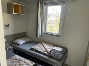 a small room with a bed and a window at Mobilhome camping 4étoiles Côte d'Azur in Cagnes-sur-Mer