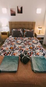 a bedroom with a large bed with a floral bedspread at De Madrid al cielo in Madrid