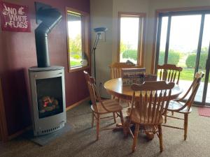 a dining room with a table and a wood stove at The Lair at Crimson House in Pullman
