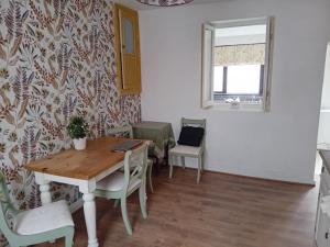 una sala da pranzo con tavolo, sedie e finestra di Cottage Style in Ystrad, Double room a Llwyn-y-pia