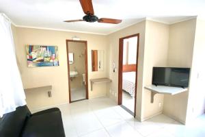 ein Wohnzimmer mit Deckenventilator und Fernseher in der Unterkunft 100m da Rodoviaria, 600m da UFV, Ar Condicionado, Elevador e Garagem Paga in Viçosa