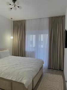 a bedroom with a bed and a large window at Neutral Nest in Sibiu