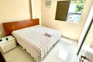 ein kleines Schlafzimmer mit einem Bett und einem Fenster in der Unterkunft 100m da Rodoviaria, 600m da UFV, Ar Condicionado, Elevador e Garagem Paga in Viçosa