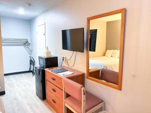 a room with a bedroom with a bed and a mirror at Super 7 Motel in Coralville