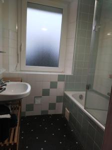 ein Bad mit einem Waschbecken, einer Badewanne und einem Fenster in der Unterkunft Maison de location Pengourven in Plouguerneau