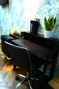 ロンドンにあるファウンテン ホテルの黒い机と椅子、植物