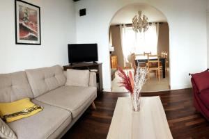 ein Wohnzimmer mit einem Sofa und einem Tisch in der Unterkunft Maison de location Pengourven in Plouguerneau