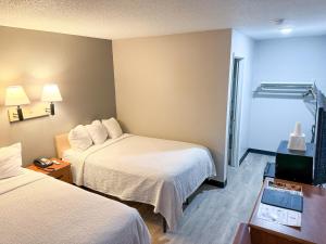 une chambre d'hôtel avec deux lits et une télévision dans l'établissement Super 7 Motel, à Coralville
