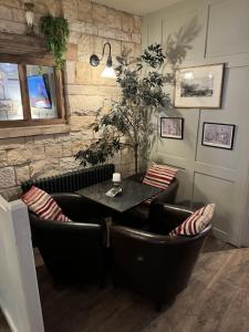 comedor con mesa y sillas de cuero en The White Lion Hotel, en Upton upon Severn