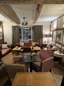 a living room with couches and a table and chairs at The White Lion Hotel in Upton upon Severn