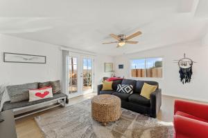 a living room with a couch and a ceiling fan at Cozy Stylish Home in the Heart of JT Village in Joshua Tree