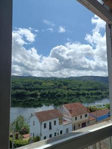 een raam met uitzicht op een rivier bij Casa de las Ascuas in Ourense