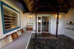 a bathroom with a tub and a sink at MADIROKELY HOUSE Nosy Be in Ambatoloaka