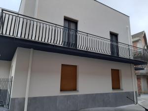 ein weißes Gebäude mit Balkon darüber in der Unterkunft Villa Giardiso in Valguarnera Caropepe