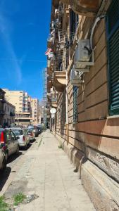 una acera vacía junto a un edificio con coches aparcados en Giachery House Palermo, 4 min. dalla stazione Giachery en Palermo