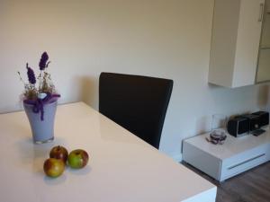 una mesa con manzanas y un jarrón de flores. en Ferienwohnung am Pfarrhof, en Ziethen