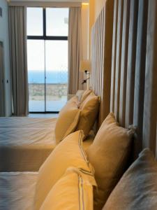 una camera d'albergo con letto con cuscini e finestra di Al Capri Suite Isola di Capri a Capri