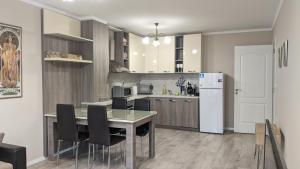 a kitchen with a table and chairs and a refrigerator at Lux 2 Central Apartment with Garage in Plovdiv