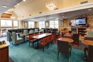 a restaurant with tables and chairs and a tv at Residence Inn by Marriott Whitby in Whitby