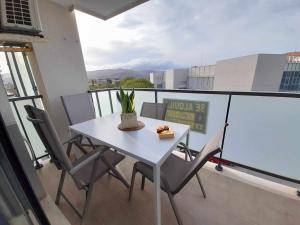 un tavolo bianco e sedie su un balcone di Apartament Ambar Gandia playa-grao con piscina parking ideal para familias a Gandía