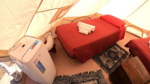 Una habitación con una cama y una máquina en una tienda de campaña en Gole Alcantara mini Glamping Lanternavacanze, en Motta Camastra