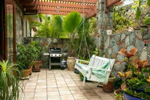 a patio with a stove and a bench and some plants at Windsong Villa - Sleeps 8 Stunning Views in Cruz Bay
