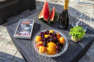 un cesto di frutta su un tavolo con una bottiglia di vino di ClickSardegna Villa dei Limoni with pool close to the beach a Fertilia