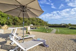 a chair and an umbrella sitting on a gravel yard at ClickSardegna Villa dei Limoni with pool close to the beach in Fertilia