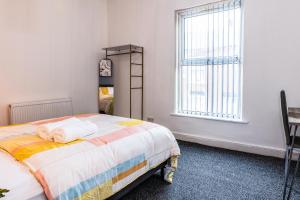 1 dormitorio con cama y ventana en Stylish 2 bed house 7mins to Manchester City center en Mánchester