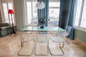 uma sala de jantar com uma mesa de vidro e 4 cadeiras em Apartamento Arrayan em Sevilha