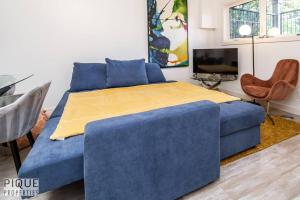 Un dormitorio con una cama azul con una manta amarilla. en Spacious Modern Suite - King Bed - Central - WiFi! en Edmonton