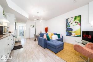 a living room with a blue couch and a tv at Spacious Modern Suite - King Bed - Central - WiFi! in Edmonton