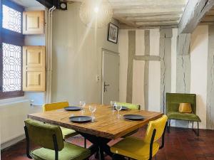 - une salle à manger avec une table et des chaises en bois dans l'établissement Le Pigeonnier centre historique Auxerre, à Auxerre