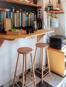 a counter with two stools and a shelf with books at Birdnest Apartment in Budapest