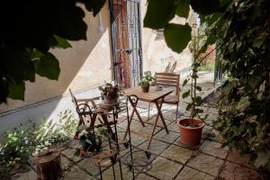 een patio met een tafel en stoelen met planten bij Birdnest Apartment in Boedapest