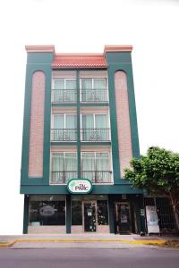 un grand bâtiment vert avec un panneau devant. dans l'établissement Hotel Du Parc, à Poza Rica de Hidalgo