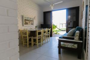 a dining room and living room with a table and chairs at Residencial Tropical in Florianópolis