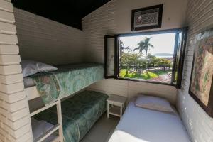 a room with two bunk beds and a window at Residencial Tropical in Florianópolis