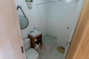 a bathroom with a toilet and a sink and a mirror at Residencial Tropical in Florianópolis