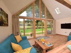 Durley的住宿－Nettlebed Farm Holiday Lets Barn3，客厅设有蓝色的沙发和大窗户