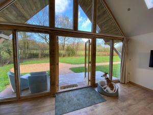 un cane seduto in una ciotola davanti a una porta di vetro di Nettlebed Farm Holiday Lets Barn3 a Durley Altre 10 foto